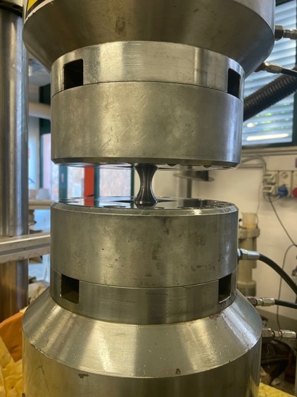 Hollow cylindrical specimen installed in the Schenck grips during setup of the internal-pressure fatigue tests.